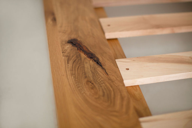Close-up of the white oak wood grain and matte finish on a bed frame