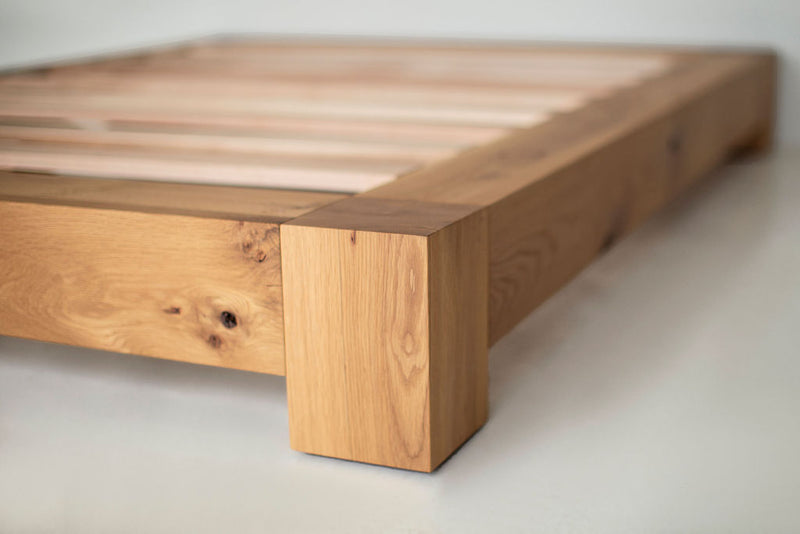 Angled view of a platform bed showing its architectural wood detailing