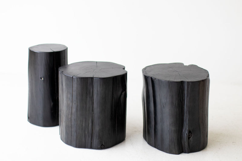 Black tree stump side tables grouped together as a coffee table
