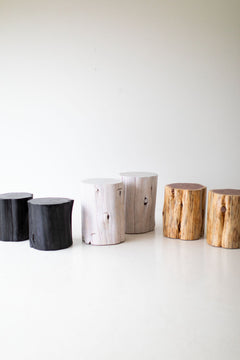 Black, whitewash and natural red cedar stump tables in a row