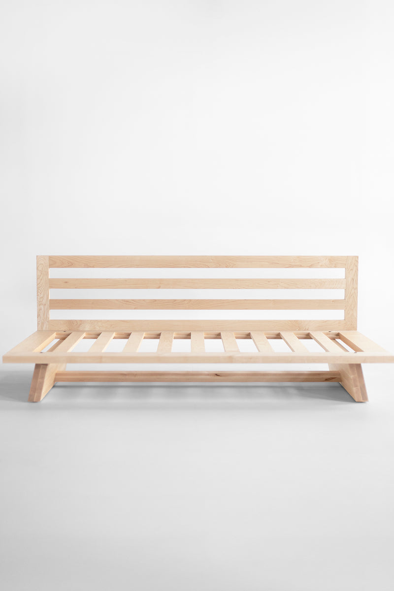 Full room view of the Sabi maple daybed paired with modern decor
