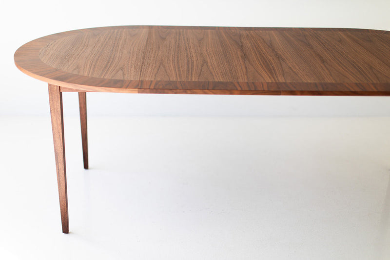 Round dining table styled with chairs and place settings in a modern luxury dining room