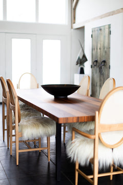 Full view of the striped top dining table against a neutral backdrop