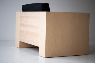 Organic modern Mondo maple lounge chair with black thick weave fabric styled in a minimal living room