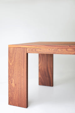 Front view of a Chile slatted dining table showing its chunky wood legs