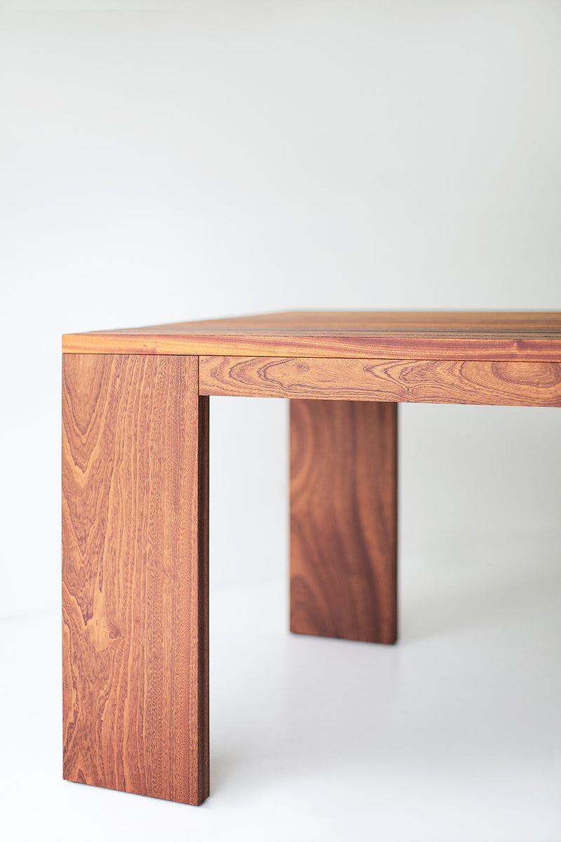 Front view of a Chile slatted dining table showing its chunky wood legs