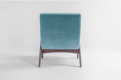 Angled view of the modern Scoop lounge chair showing its sculptural walnut silhouette, luxury Craft Associates® seating