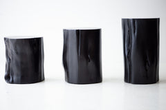 Black stump side table styled in a bright interior