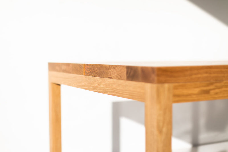 Modern luxury white oak dining table shown from the side