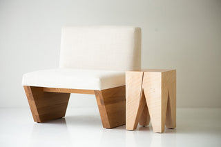Natural maple Vega beside a lounge chair