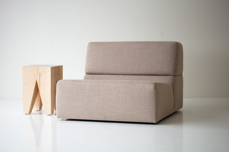 Natural maple Vega as a side table beside a sofa