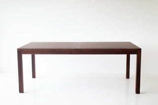 Modern walnut dining table with clean tapered legs and an extendable top