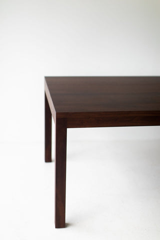 The Christopher modern walnut dining table styled with chairs in a dining room