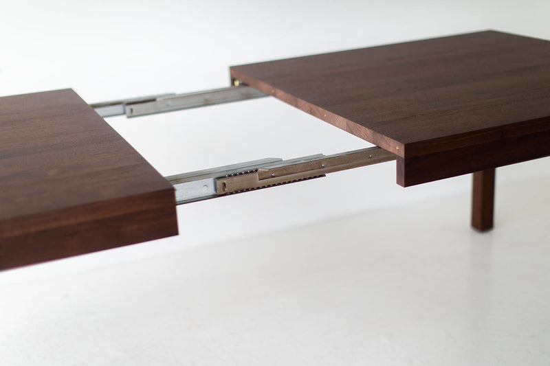 Side profile of the walnut dining table showing its simple silhouette