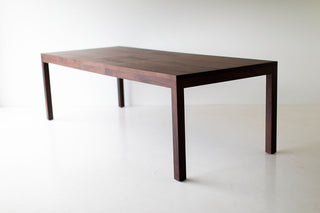 Walnut dining table styled in a bright dining room