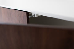 Modern luxury walnut Cambre credenza shown at an angle, highlighting its curved silhouette