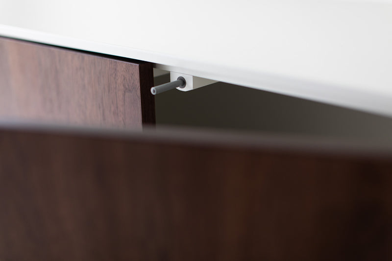 Modern luxury walnut Cambre credenza shown at an angle, highlighting its curved silhouette