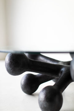 Angled view of the bronze coffee table with round glass top