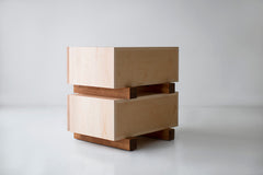 Open drawer on a modern maple nightstand showing interior storage