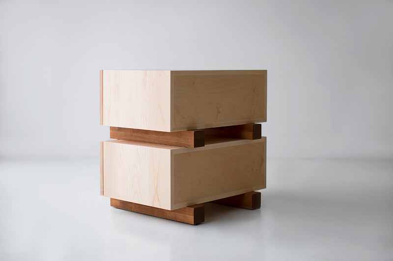 Open drawer on a modern maple nightstand showing interior storage