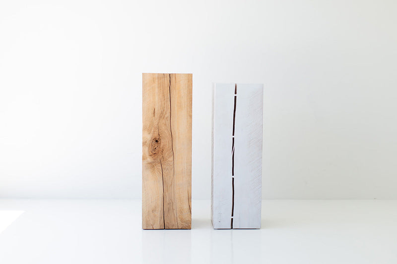 Natural and whitewash maple art pedestals with a person walking past