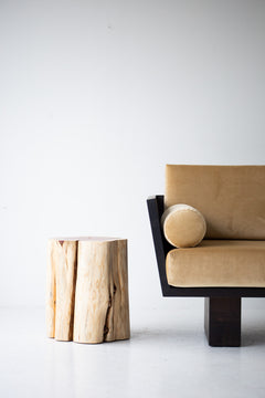 Natural stump side table styled beside a modern sofa