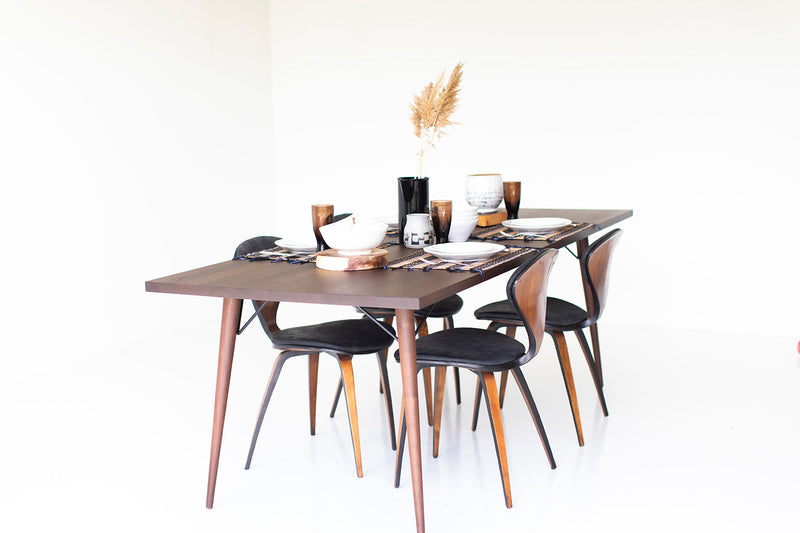 The modern luxury New York walnut dining table shown in a modern interior