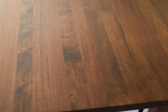 Close-up of the solid steel X-brace on the modern luxury walnut dining table