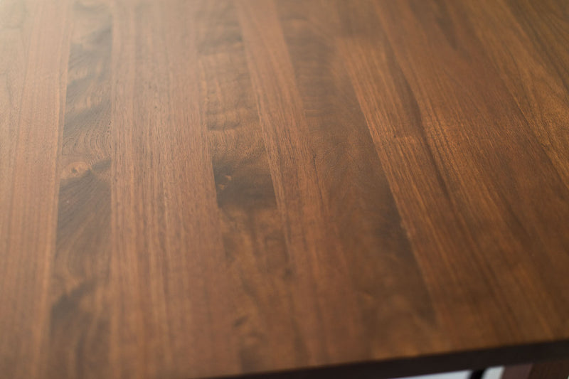 Close-up of the solid steel X-brace on the modern luxury walnut dining table
