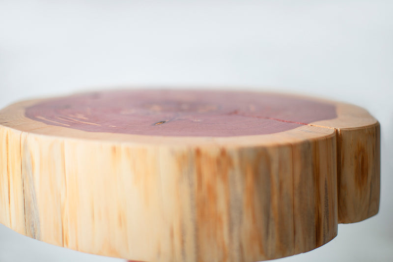 Front view of a red cedar Summit side table showing its organic stump shape