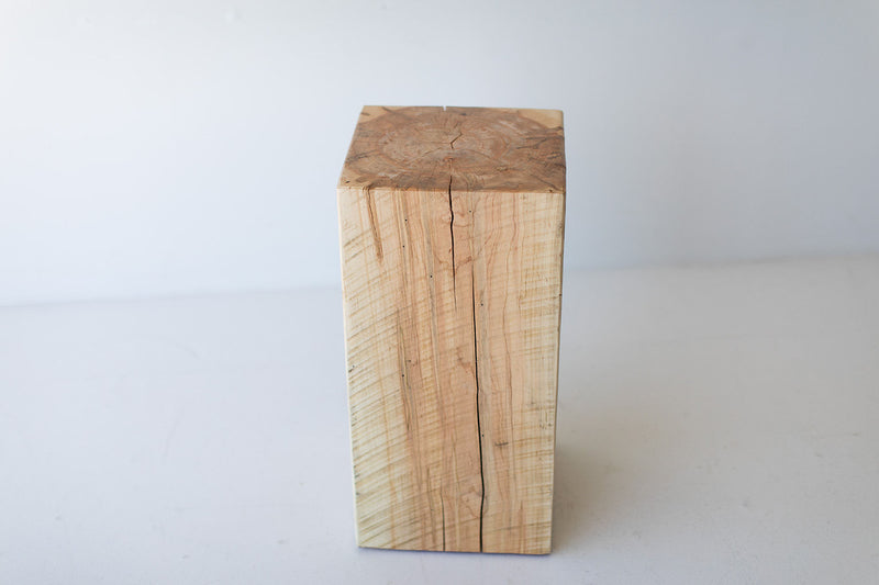 Tree stump table paired with a mid-century chair for a natural, organic living space