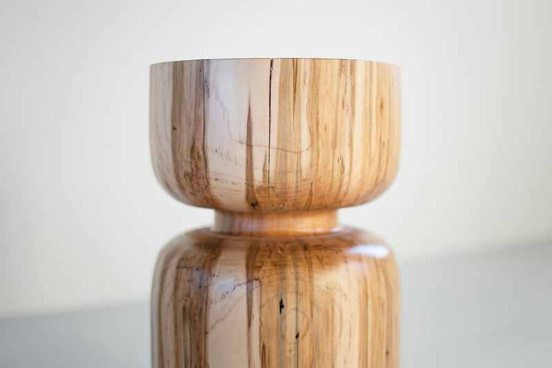 Side profile of a natural wood stool highlighting its sculpted Boca shape