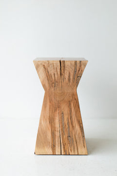 The Sol end table styled next to a chair in a living room