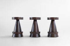 The Outdoor Boca counter stool hand-sculpted from solid walnut with an exterior finish, shown from the front.