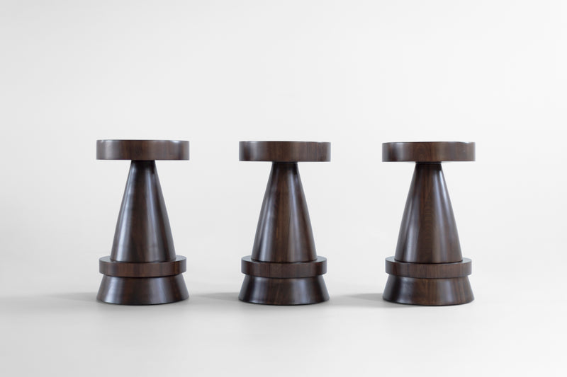 The Outdoor Boca counter stool hand-sculpted from solid walnut with an exterior finish, shown from the front.