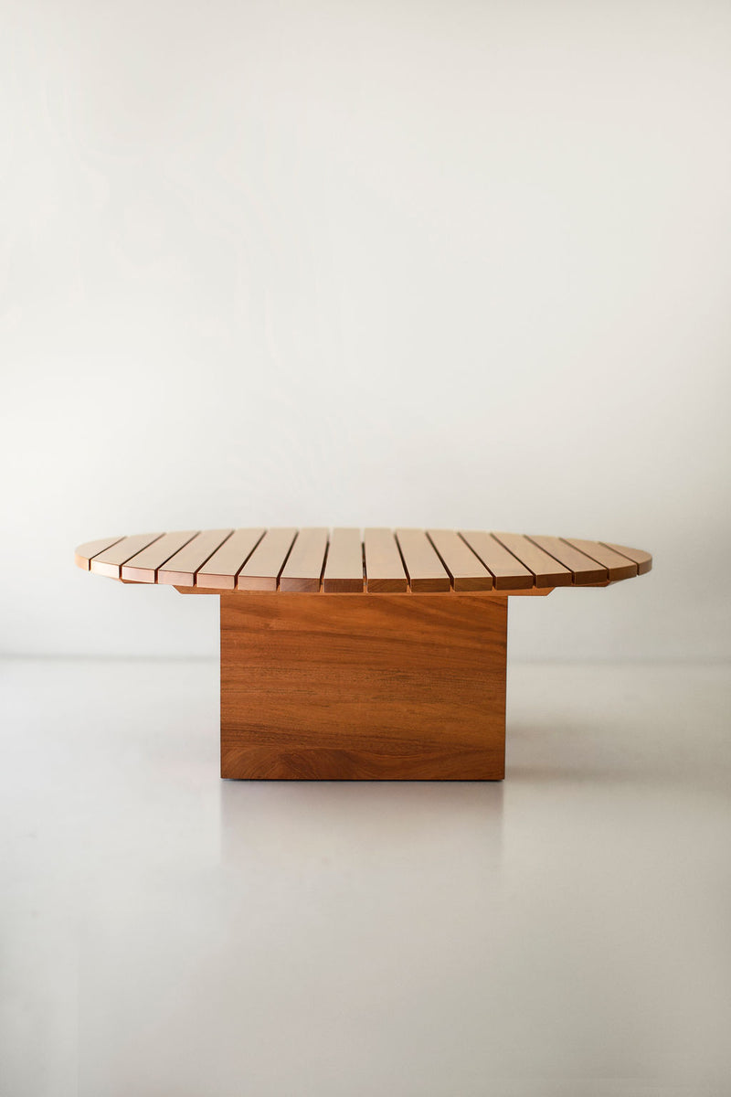 Full view of an outdoor round coffee table against a white backdrop