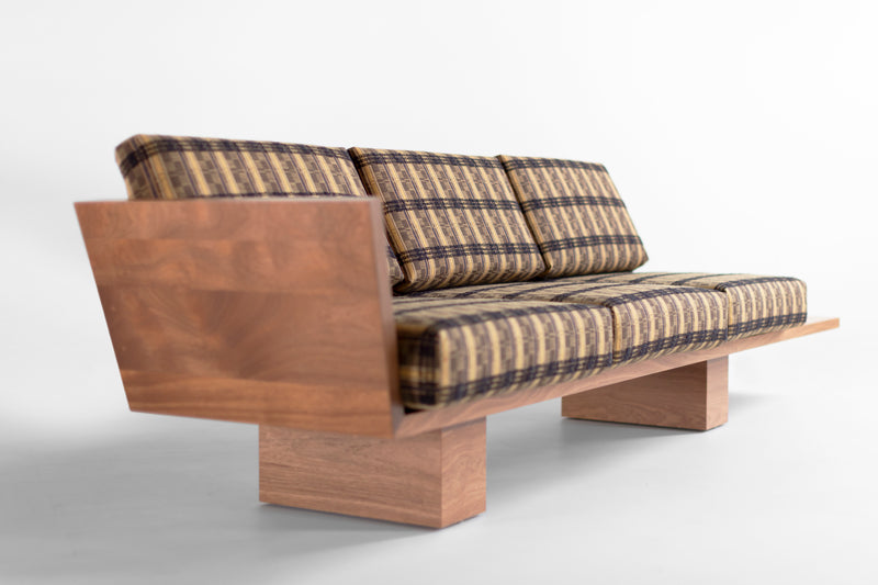 Side profile of an outdoor sofa highlighting the wood platform side table