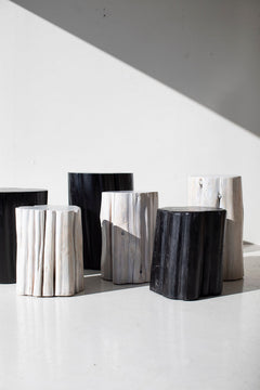 Black and whitewash outdoor stump tables grouped in sunlight