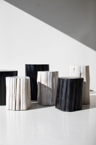Black and whitewash outdoor stump tables grouped in sunlight