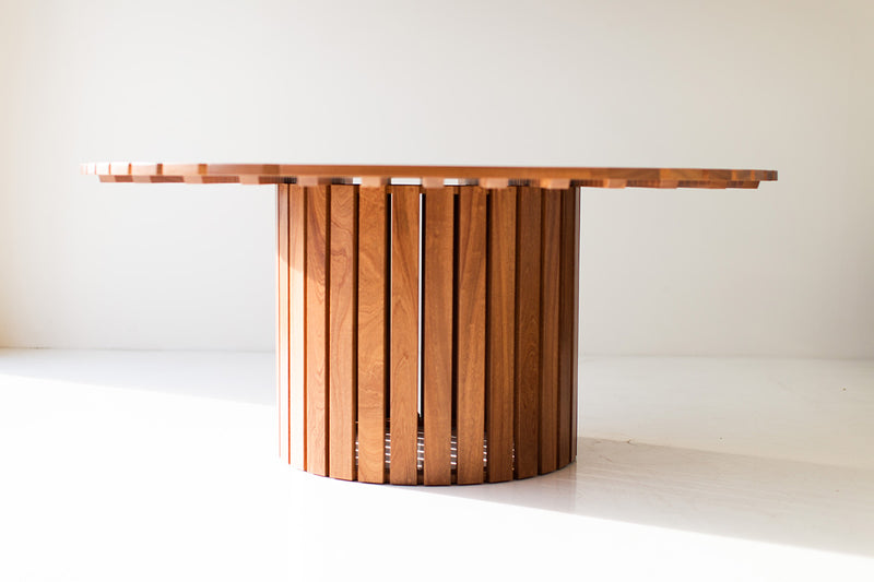 Round outdoor wood dining table styled in a bright outdoor space