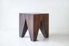 Front view of a Vega stump table showing its sculpted maple shape