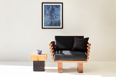 Solid wood side table styled next to a chair as a nightstand