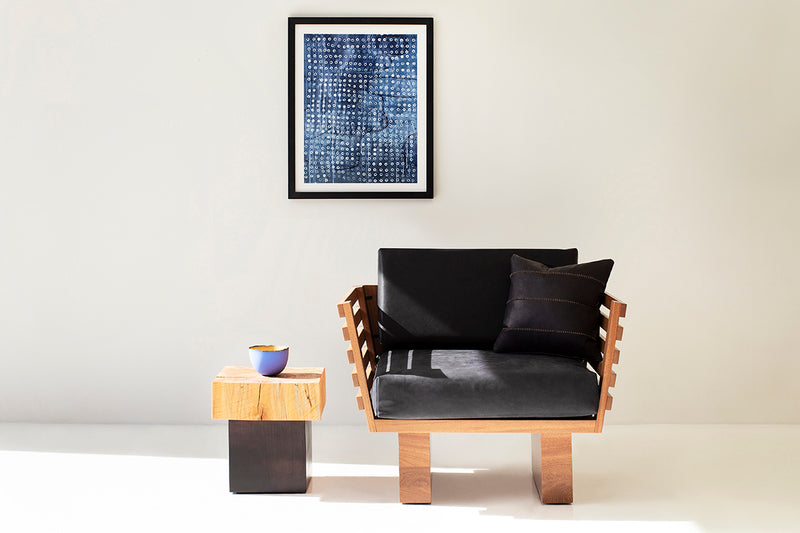 Solid wood side table styled next to a chair as a nightstand