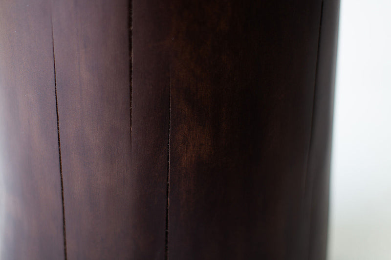 Side profile of the solid walnut stump table showing its tall, organic form