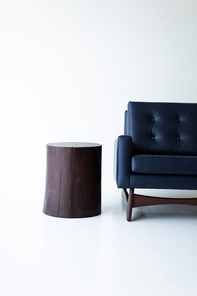 Solid walnut stump table styled beside a sofa in a living room