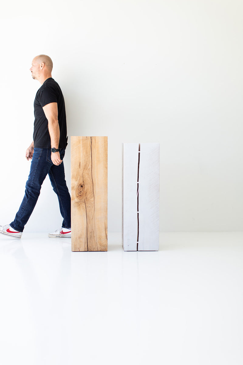 Natural and whitewash maple art pedestals with a person walking past