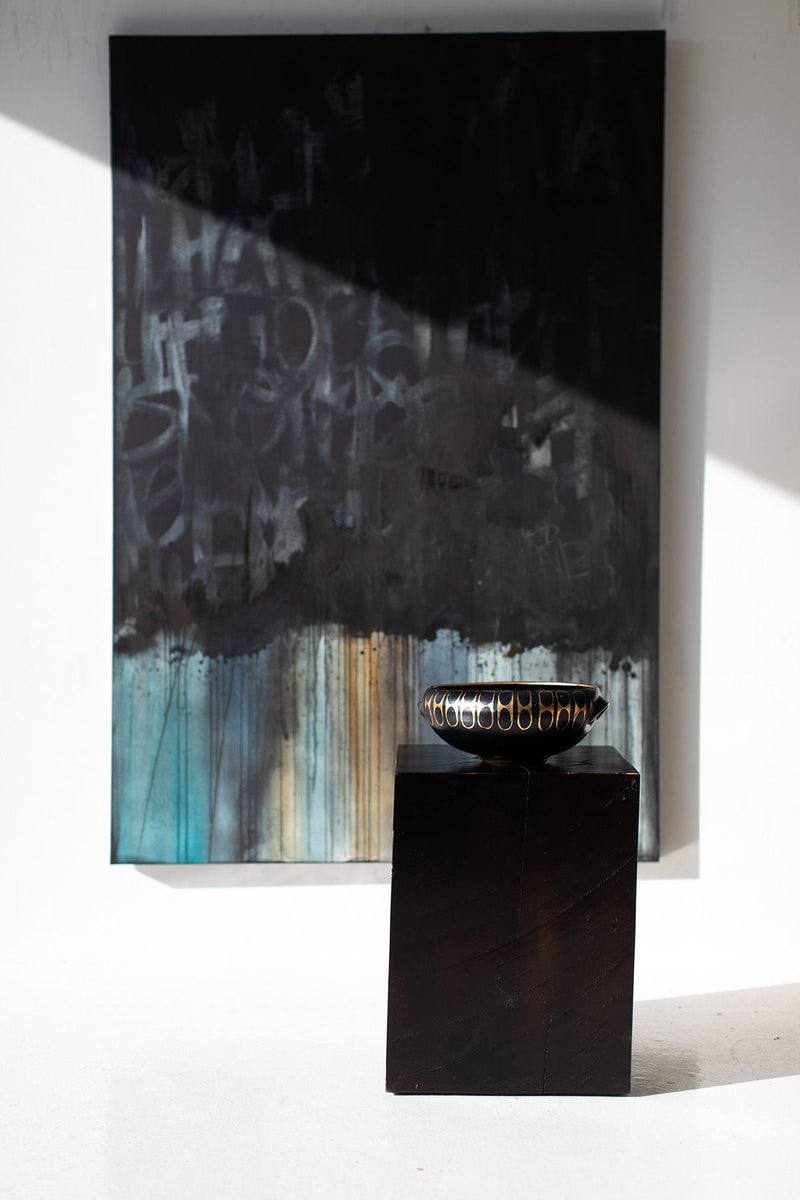 Black maple block end table in front of a painting