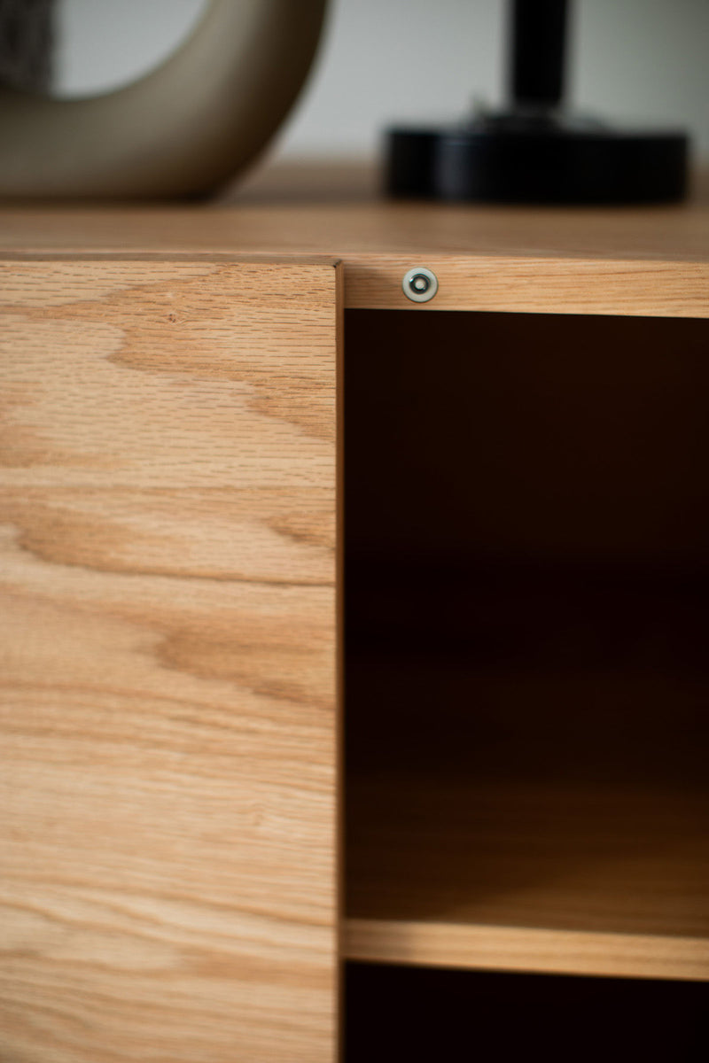 Modern oak Suelo credenza styled with decor in a dining room
