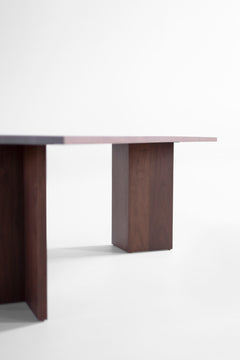 Angled view of the Triad walnut dining table highlighting its sleek modern silhouette