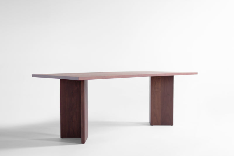 Close-up of the walnut wood grain and commercial-grade finish on the Triad table